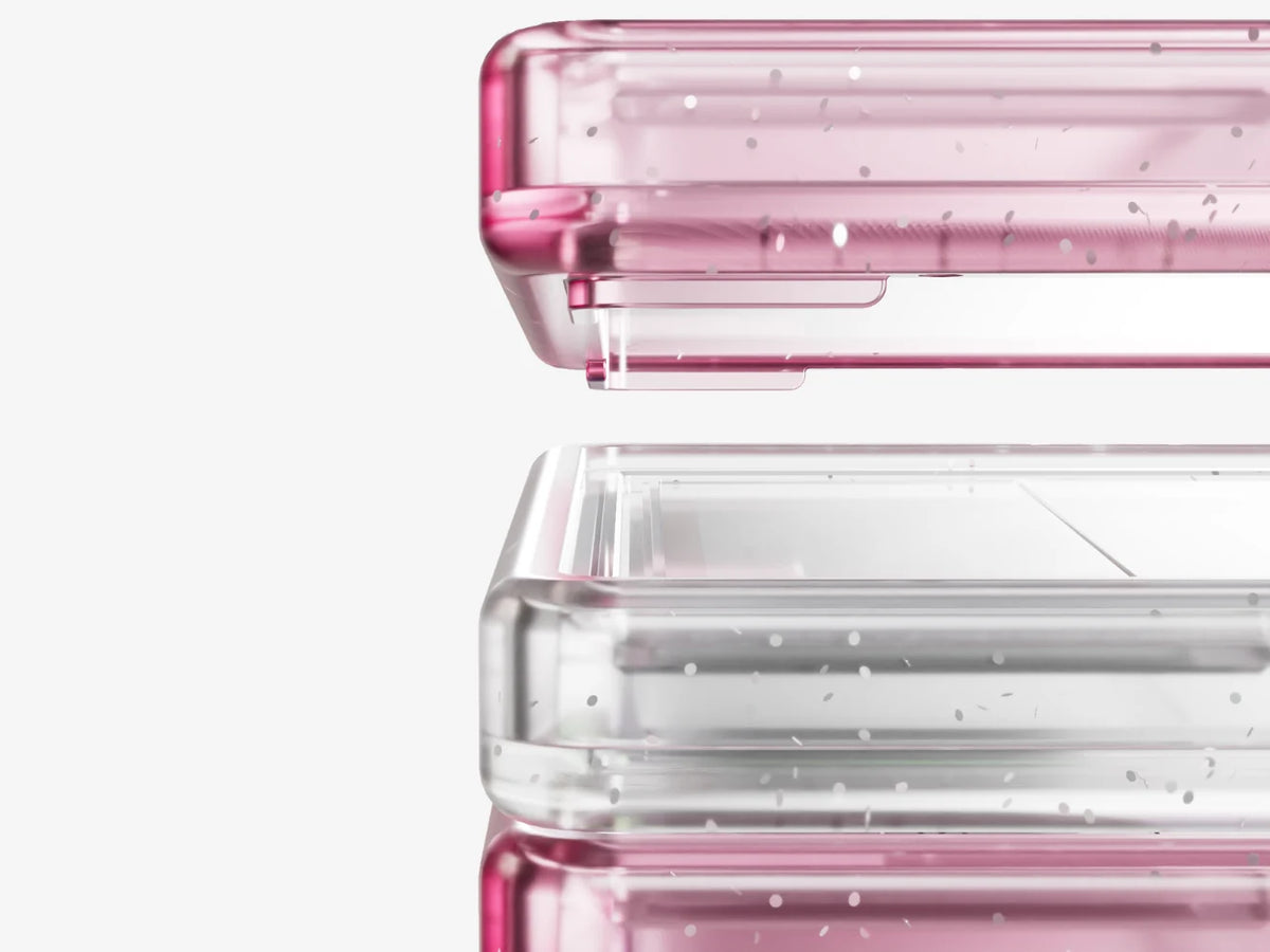 Close-up of stacked Bumpii Lychee graded card guard frames showing translucent pink and clear corner details.